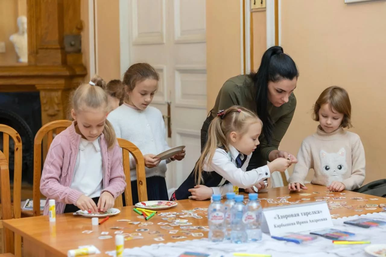 Девочки собирают из наклеек «здоровую тарелку» на занятии